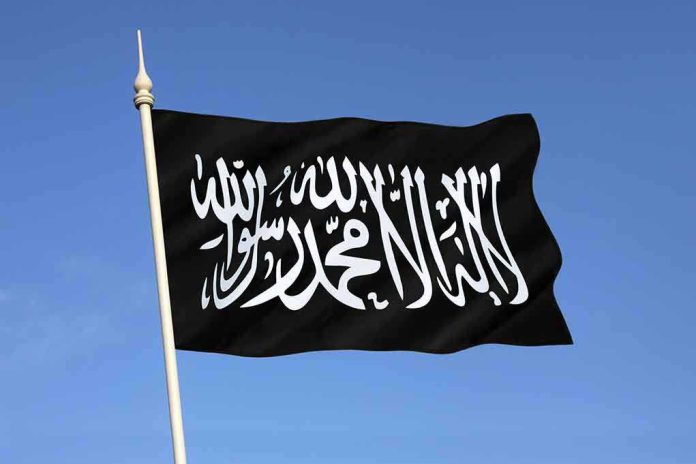 Black flag featuring Arabic script against a blue sky