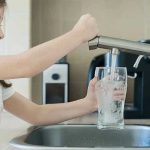 Drink More Water? Study Says No Impact Girl filling glass with water from kitchen faucet.