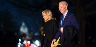First Lady’s Shocking Pardon Defense Two people walking outdoors at night, lights behind.