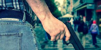 Spring Violence EXPLODES in Chicago – SHOCKING Stats Person holding a gun in a crowded street.