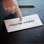 Envelope with YOURE FIRED and pointing finger.