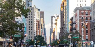 Chinese Robots INVADING U.S. Streets? City street with pedestrian crossing and traffic.