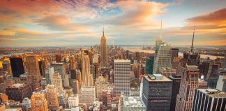 Banks Manipulate Wars? The Unseen Truth Aerial view of New York City skyline during sunset with skyscrapers and clouds