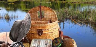 Wildlife Management Turns Criminal in Oregon! Fishing gear including a hat, basket, and fishing rods arranged by a serene water body
