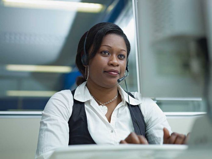 shutterstock_67733821.jpg A woman wearing a headset, focused on her work at a computer in an office setting
