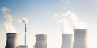 Four cooling towers of a power plant emitting steam.
