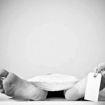 Bare feet with toe tag on body covered by sheet.