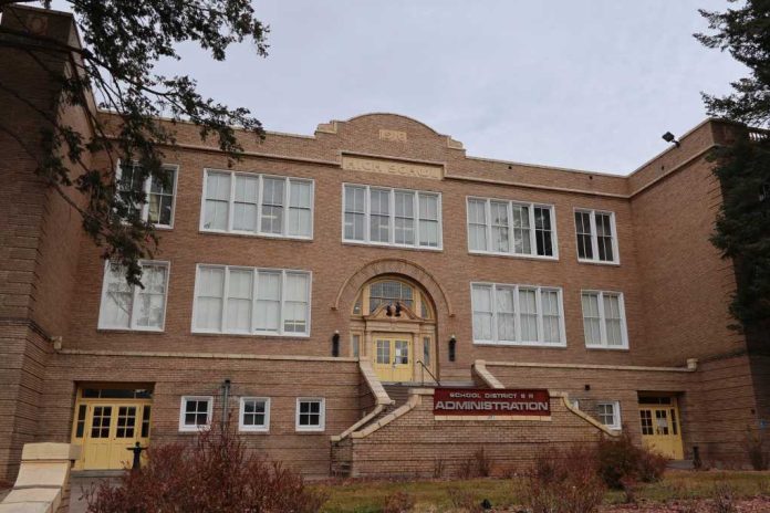 Historic brick school building with arched entrance and large white-framed windows