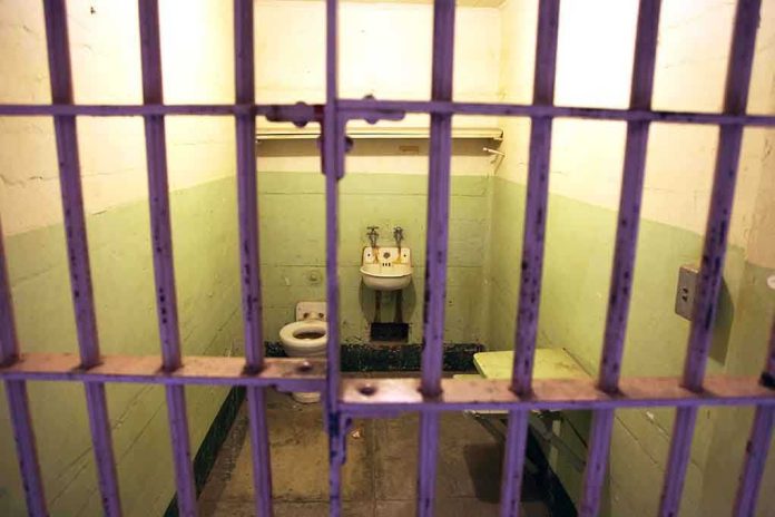 shutterstock_208632826-1 Interior of a prison cell with a toilet, sink, and metal bars