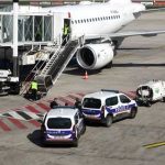 Police vehicles near an airplane at an airport