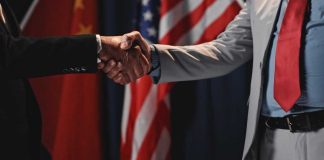 Iran Declared the War Over “Immediately and Permanently” — Read the Fine Print Two individuals shaking hands in front of flags