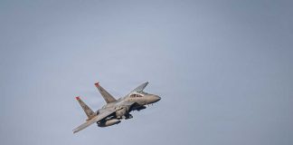 A military fighter jet flying against a clear sky