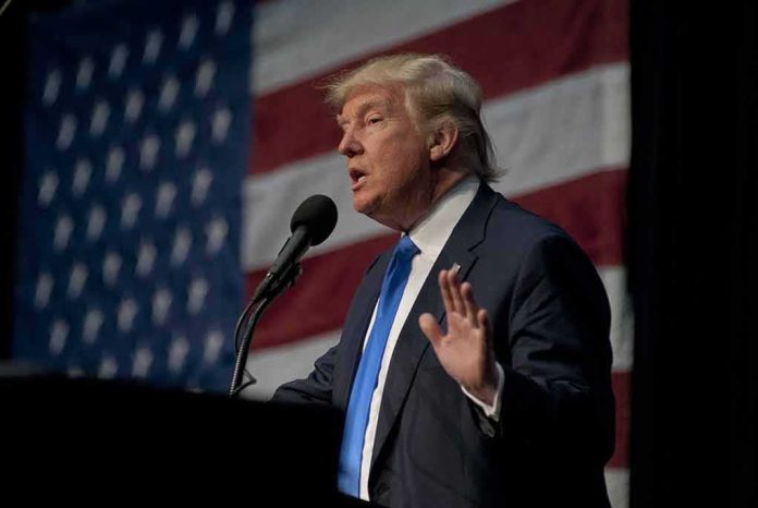 shutterstock_787487767-1 man in suit speaking at a podium with a US flag backdrop