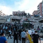Global Quake Flurry — Only One True Link People at a collapsed building after an earthquake.
