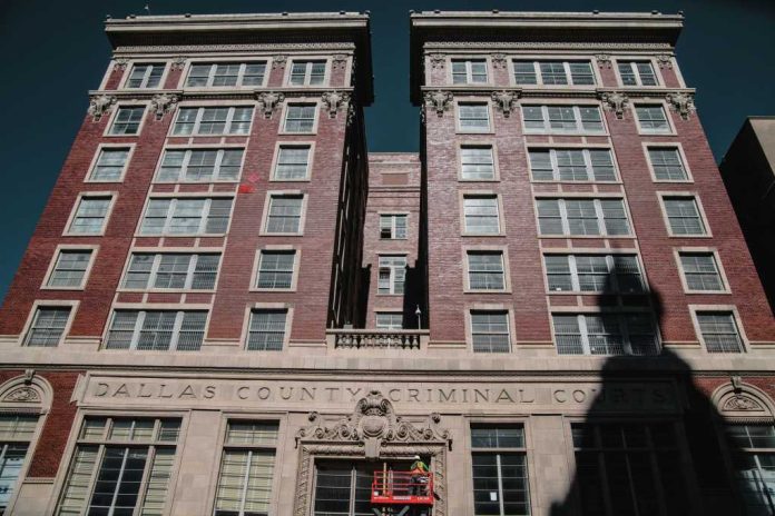 Dallas County Criminal Courts building facade with worker on lift