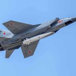 NORAD Jets Roar Over Final fighter jet with missile flying against a clear blue sky