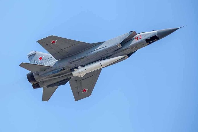 shutterstock_1085562689 fighter jet with missile flying against a clear blue sky