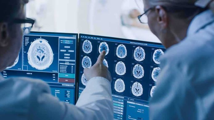 shutterstock_1243951690 Doctors reviewing brain MRI scans on multiple monitors