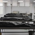 Mud-Filled Lungs Upend Accident Story Mortuary room with covered bodies on metal gurneys
