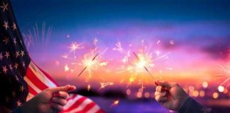 Corporate Flag-Waving Frenzy Sparks Backlash Hands holding sparklers with American flag background.