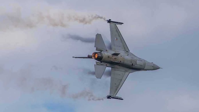 shutterstock_2143879765 Fighter jet banking with afterburner against a cloudy sky