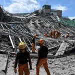 Rescue workers search a collapsed building site