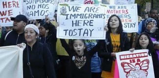 Protesters march holding signs and banners