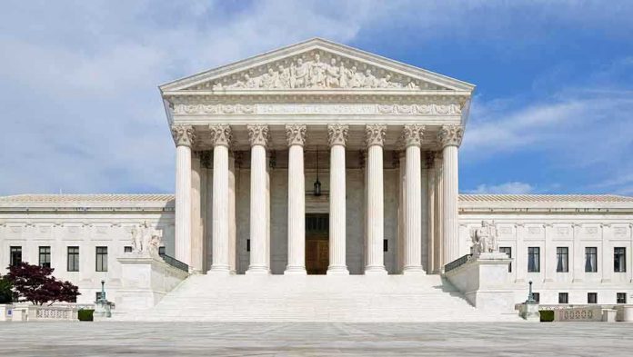 shutterstock_132568517 Front view of the Supreme Court building with large columns and steps under a blue sky