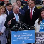 24-Week Limit Scrapped — Who Draws The Line? Group of people at a press conference with microphones and protest signs