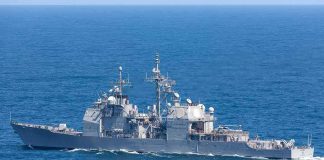 Powerless Destroyer Towed Under Watch Gray naval warship cruising on open sea