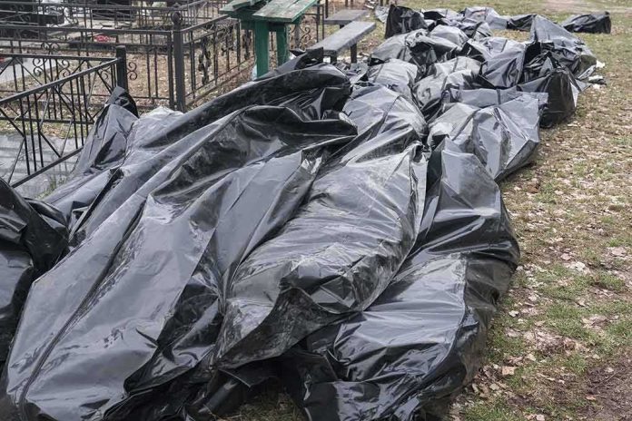 shutterstock_2203463897 Black plastic bags piled outdoors near metal fencing