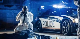 He Was Already Shot—Then Police Allegedly Fired forensic investigator photographing crime scene near police car