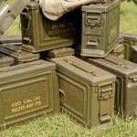 Military Scrap Vanishes Overnight Stack of green military ammunition boxes on grass