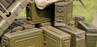 Military Scrap Vanishes Overnight Stack of green military ammunition boxes on grass