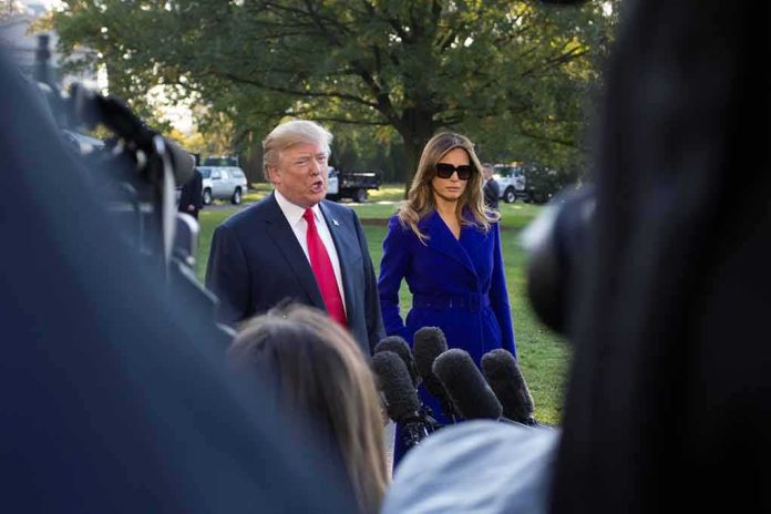 Two adults speak to reporters outdoors with microphones in foreground