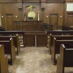 A Famous NFL Star Got Caught In This Scheme Interior view of an empty courtroom with wooden benches and a judges bench