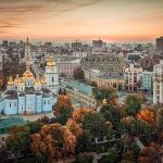 Cityscape with blue-gold domed cathedral at sunset