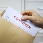 China-to-U.S. Pipeline Exposed – GLP-1 Chaos Hand placing confidential document into a brown envelope