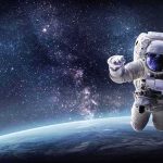 Scientists Just Witnessed The Earliest Days Of A Planet Astronaut floating above Earth against a starry galaxy backdrop