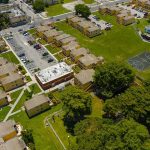 Aerial view of apartment complex with parking lots and a basketball court