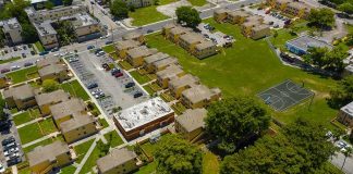 Aerial view of apartment complex with parking lots and a basketball court