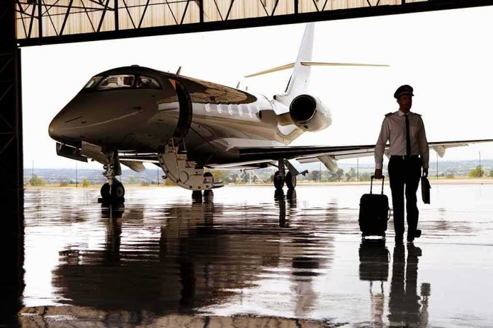 shutterstock_1586690725 Pilot walking with suitcase beside private jet in hangar