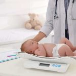 Judge Says Mom Insane—Now What? Pediatrician weighing a baby on an infant scale