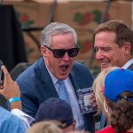 TRUMP’s $1 Trillion Deregulation Shocker Two men in suits smiling among a crowd at an outdoor event