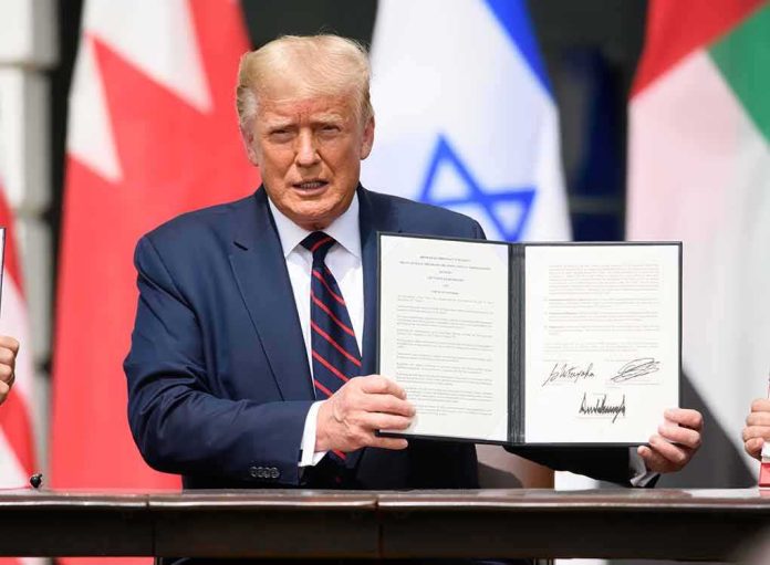 shutterstock_1816392461-1 Donald Trump holding a signed document at a ceremony