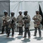 The Soccer Tournament Requiring Military-Level Security Line of soldiers in riot gear standing on a city street