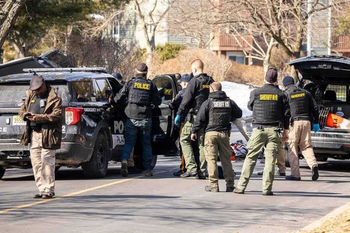 shutterstock_2126536382 Police and sheriff officers gather around vehicles on a suburban street