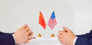 Markets Sigh – Tariff Drama Reloads January 10 Two diplomats sit across table with China and United States flags between them