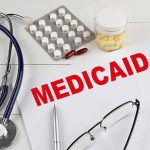 Medicaid Heist Exposed — Judge Lowers Boom Medicaid document with stethoscope and medications on desk