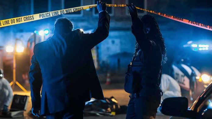 shutterstock_2230644499 Investigators at night lifting police tape at a crime scene